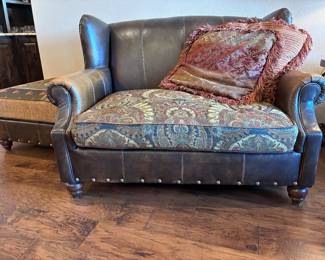 leather wing chair-and-a-half with a paisley fabric seat cushion and nailhead trim, by King Hickory.