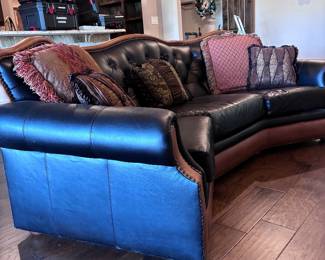 classic curved western-style leather sofa featuring a tufted seat back and saddle tan leather accents