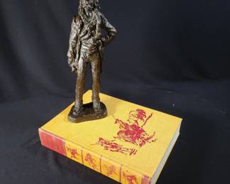 Lot # : 4 - G. Kadath Bronze Sculpture and Book Bronze sculpture titled ‘Waitin’’ by G. Kadath, numbered 7/100, displayed atop a hardcover copy of ‘The Book of the American West,’ published by Julian Messner in 1963, first edition. Sculpture signed and numbered on the base.