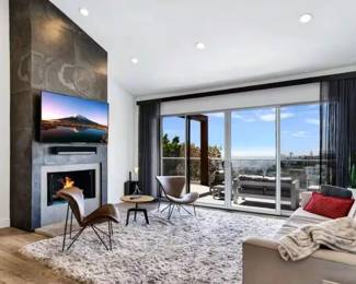 Carpet, television, living room chairs and coffee table, wall art