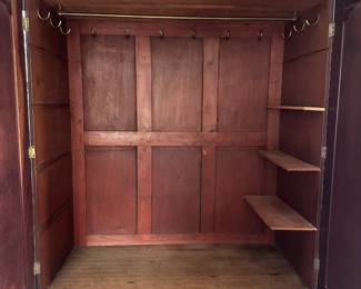 Interior of armoire - brass hooks and shelving for accessories