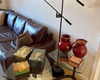 Another view of the leather sectional, black floor lamp with double cantilever arms, and matched set of glass and metal side tables