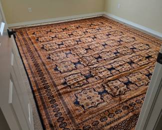 Room size burnt orange and navy Pakistani rug in excellent condition.