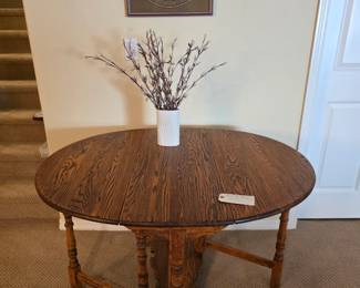Gateleg oval drop leaf table in opened position.