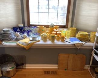 White and blue set of China, glassware, multiple colors of yellow mugs, plates, pitcher, canisters plus a set of yellow China. Many table linens to match