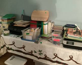 An abundance of office supplies: copier, stapler, post it notes, cards, scissors