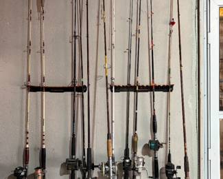 Large selection of shimano, pfluger, and Shakespeare fishing reels mounted on poles. 