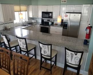 Nice U-shaped kitchen with plenty of cabinets and a pantry; 5 bar stools; pendant lights