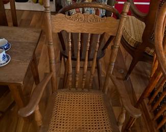 Antique Oak Spindle Back Rocking Chair with Carved Crest Rail and Cane Seat