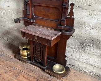This lot features a stunning late 19th century Eastlake Victorian hall tree with a marble top drawer, umbrella trays, and brass hooks. This piece measures, 84” H x 35” W x 12” D.