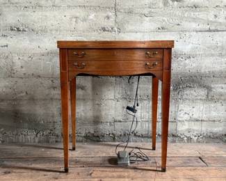 This lot features an antique sewing machine cabinet that is housing a White model 530 with a pedal as shown in photos. Comes untested, but appears to be in very good condition and measures (closed), 31.5” H x 27” W x 19” D.