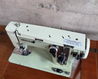 This lot features an antique sewing machine cabinet that is housing a White model 530 with a pedal as shown in photos. Comes untested, but appears to be in very good condition and measures (closed), 31.5” H x 27” W x 19” D.