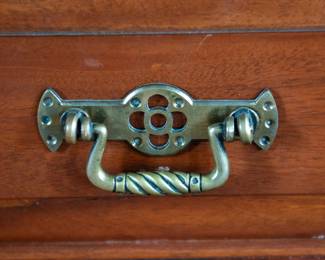 A large mahogany sideboard with an attached mirror by Aldis & Leggott, cabinet makers from Hull. The piece features four drawers, two side cabinets with pull-out shelves, and a specialized interior section for bottle storage. Decorative carvings on the legs and facade, as well as brass drawer pulls, highlight the craftsmanship. Dovetail joinery is observed on the drawers, indicating quality construction. The mirror shows minor silvering loss, and the wooden structure displays some signs of wear consistent with age, including small scratches and woodworm holes. Stamped “Aldis & Leggott, 17 Paragon Street, Hull”. This stunning sideboard measures 77” H X 78” W x 26” D.