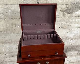 This lot features a Hardwick 4-drawer chest by Butler Speciality and a Reed & Barton utensil storage chest sitting on top. This piece measures (with top utensil box), 42” H x 18” W x 14” D.