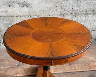 This lot features a 19th-century Biedermeier-style pedestal side table with a single drawer that measures, 20” H x 19” W x 13.5” D.