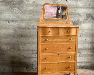 This lot features a stunning highboy dresser with a harp mirror with six (6) drawers and sitting on casters. This dresser measures with mirror, 65” H x 33.5” W x 18” D.