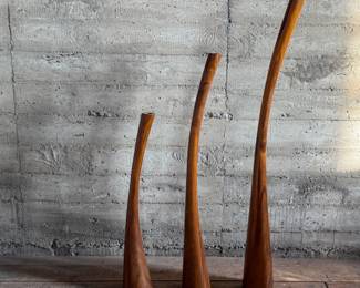 This lot features the Three Gading Candle Holder Set which includes three beautifully crafted pieces made from natural Suar wood, each showcasing the wood’s unique grain patterns and rich, organic textures. The color of the wood may vary, adding a distinctive touch to each holder. Designed to hold your favorite candles, these holders bring warmth and rustic elegance to any space, whether as a centerpiece or accent piece. Perfect for adding a natural, earthy charm to both modern and traditional interiors, the Three Gading Candle Holder Set elevates your home décor with timeless beauty. The tallest measures, 62” H.