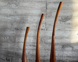 This lot features the Three Gading Candle Holder Set which includes three beautifully crafted pieces made from natural Suar wood, each showcasing the wood’s unique grain patterns and rich, organic textures. The color of the wood may vary, adding a distinctive touch to each holder. Designed to hold your favorite candles, these holders bring warmth and rustic elegance to any space, whether as a centerpiece or accent piece. Perfect for adding a natural, earthy charm to both modern and traditional interiors, the Three Gading Candle Holder Set elevates your home décor with timeless beauty. The tallest measures, 62” H.