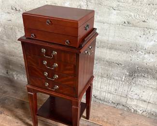 This lot features a Hardwick 4-drawer chest by Butler Speciality and a Reed & Barton utensil storage chest sitting on top. This piece measures (with top utensil box), 42” H x 18” W x 14” D.