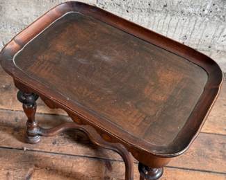 This lot features a William and Mary style walnut tea or side table, often recognized by its turned legs, scalloped apron, and stretcher base that measures, 18” H x 24” W x 16” D.