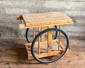 A whimsically designed Chopping Block Bar Cart by the noted California designer Bill W. Sanders. This design dates to the 1960’s. The bicycle tires may have been replaced at some point. The butcher block is in good condition. The bicycle wheels are a little wobbly when wheeled around but the cart is stable and sturdy. This cart measures, 29.5” H x 22” W x 34” D. A similar example is pictured in the book by the Pasadena Art Museum, California Design/Nine, Pasadena, 1965, Page 112.