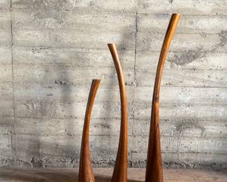 This lot features the Three Gading Candle Holder Set which includes three beautifully crafted pieces made from natural Suar wood, each showcasing the wood’s unique grain patterns and rich, organic textures. The color of the wood may vary, adding a distinctive touch to each holder. Designed to hold your favorite candles, these holders bring warmth and rustic elegance to any space, whether as a centerpiece or accent piece. Perfect for adding a natural, earthy charm to both modern and traditional interiors, the Three Gading Candle Holder Set elevates your home décor with timeless beauty. The tallest measures, 62” H.