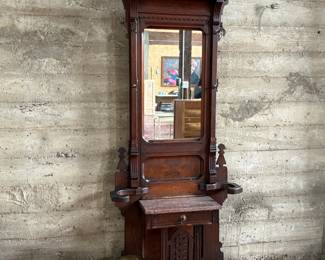 This lot features a stunning late 19th century Eastlake Victorian hall tree with a marble top drawer, umbrella trays, and brass hooks. This piece measures, 84” H x 35” W x 12” D.