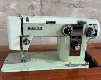 This lot features an antique sewing machine cabinet that is housing a White model 530 with a pedal as shown in photos. Comes untested, but appears to be in very good condition and measures (closed), 31.5” H x 27” W x 19” D.