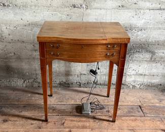 This lot features an antique sewing machine cabinet that is housing a White model 530 with a pedal as shown in photos. Comes untested, but appears to be in very good condition and measures (closed), 31.5” H x 27” W x 19” D.