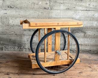A whimsically designed Chopping Block Bar Cart by the noted California designer Bill W. Sanders. This design dates to the 1960’s. The bicycle tires may have been replaced at some point. The butcher block is in good condition. The bicycle wheels are a little wobbly when wheeled around but the cart is stable and sturdy. This cart measures, 29.5” H x 22” W x 34” D. A similar example is pictured in the book by the Pasadena Art Museum, California Design/Nine, Pasadena, 1965, Page 112.