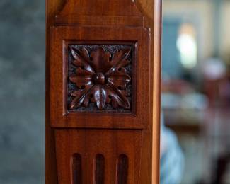 A large mahogany sideboard with an attached mirror by Aldis & Leggott, cabinet makers from Hull. The piece features four drawers, two side cabinets with pull-out shelves, and a specialized interior section for bottle storage. Decorative carvings on the legs and facade, as well as brass drawer pulls, highlight the craftsmanship. Dovetail joinery is observed on the drawers, indicating quality construction. The mirror shows minor silvering loss, and the wooden structure displays some signs of wear consistent with age, including small scratches and woodworm holes. Stamped “Aldis & Leggott, 17 Paragon Street, Hull”. This stunning sideboard measures 77” H X 78” W x 26” D.