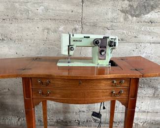 This lot features an antique sewing machine cabinet that is housing a White model 530 with a pedal as shown in photos. Comes untested, but appears to be in very good condition and measures (closed), 31.5” H x 27” W x 19” D.