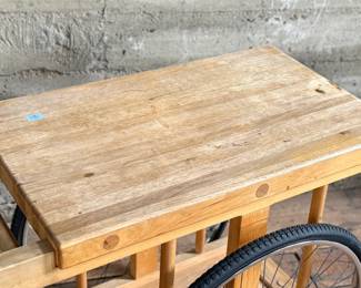 A whimsically designed Chopping Block Bar Cart by the noted California designer Bill W. Sanders. This design dates to the 1960’s. The bicycle tires may have been replaced at some point. The butcher block is in good condition. The bicycle wheels are a little wobbly when wheeled around but the cart is stable and sturdy. This cart measures, 29.5” H x 22” W x 34” D. A similar example is pictured in the book by the Pasadena Art Museum, California Design/Nine, Pasadena, 1965, Page 112.