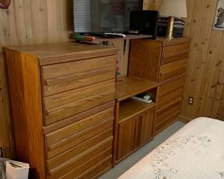 Here you can see two dressers separated by a nightstand.  The TV is resting on a wall-mounted shelf.