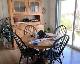 This shows a nice dining table and four matching chairs in the foreground, plus the kitchen hutch in the background.