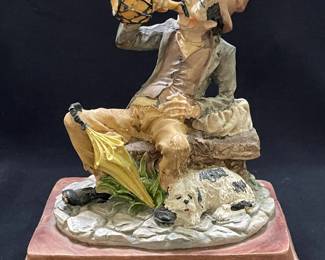 Man Sitting with Dog Figurine