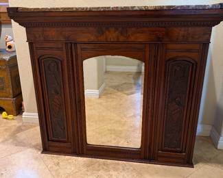 antique wooden fireplace mantel featuring a reddish-brown marble top and a centered mirror