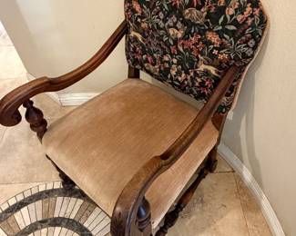 antique armchair featuring a hand-carved wood frame and a tapestry upholstery