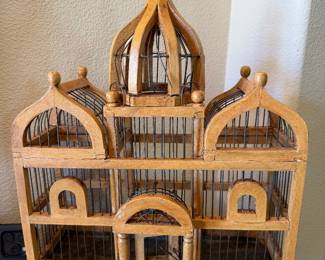 vintage wooden and metal bird cage is designed in a decorative cathedral