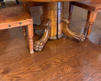 antique round oak dining table featuring carved lion's paw or claw feet