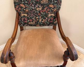 antique armchair featuring a hand-carved wood frame and a tapestry upholstery