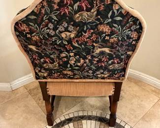 antique armchair featuring a hand-carved wood frame and a tapestry upholstery