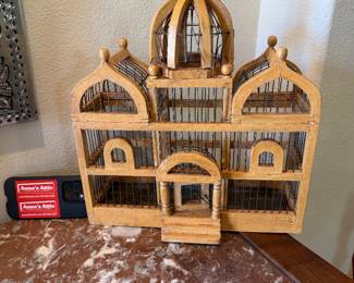 vintage wooden and metal bird cage is designed in a decorative cathedral