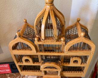 vintage wooden and metal bird cage is designed in a decorative cathedral