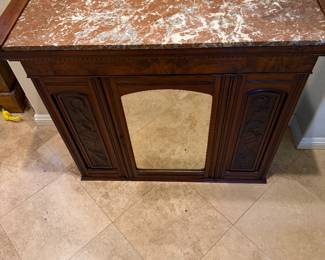 antique wooden fireplace mantel featuring a reddish-brown marble top and a centered mirror