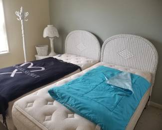 Twin beds with wite wicker headboards; wicker nightstand; wicker table lamp