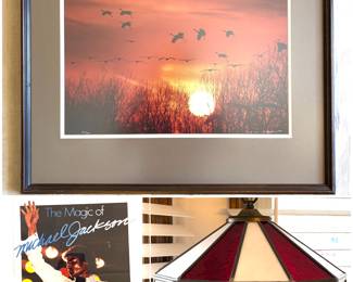 A framed Thomas D. Mangelsen collector edition print, a vintage 1984 souvenir booklet titled The Magic of Michael Jackson. and a Tiffany style Husker light. 