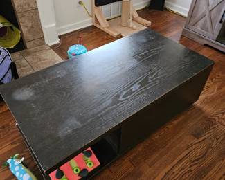 Black coffee table, top slides open and there is storage underneath