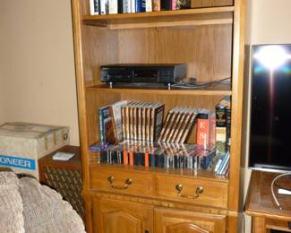 Another shelving unit with books, DVDs and cassettes