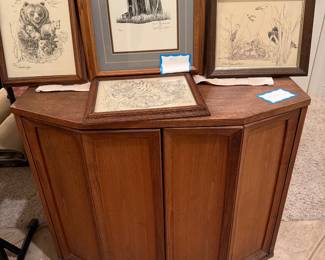 Solid wood corner cabinet with paneled doors, framed wildlife art. 